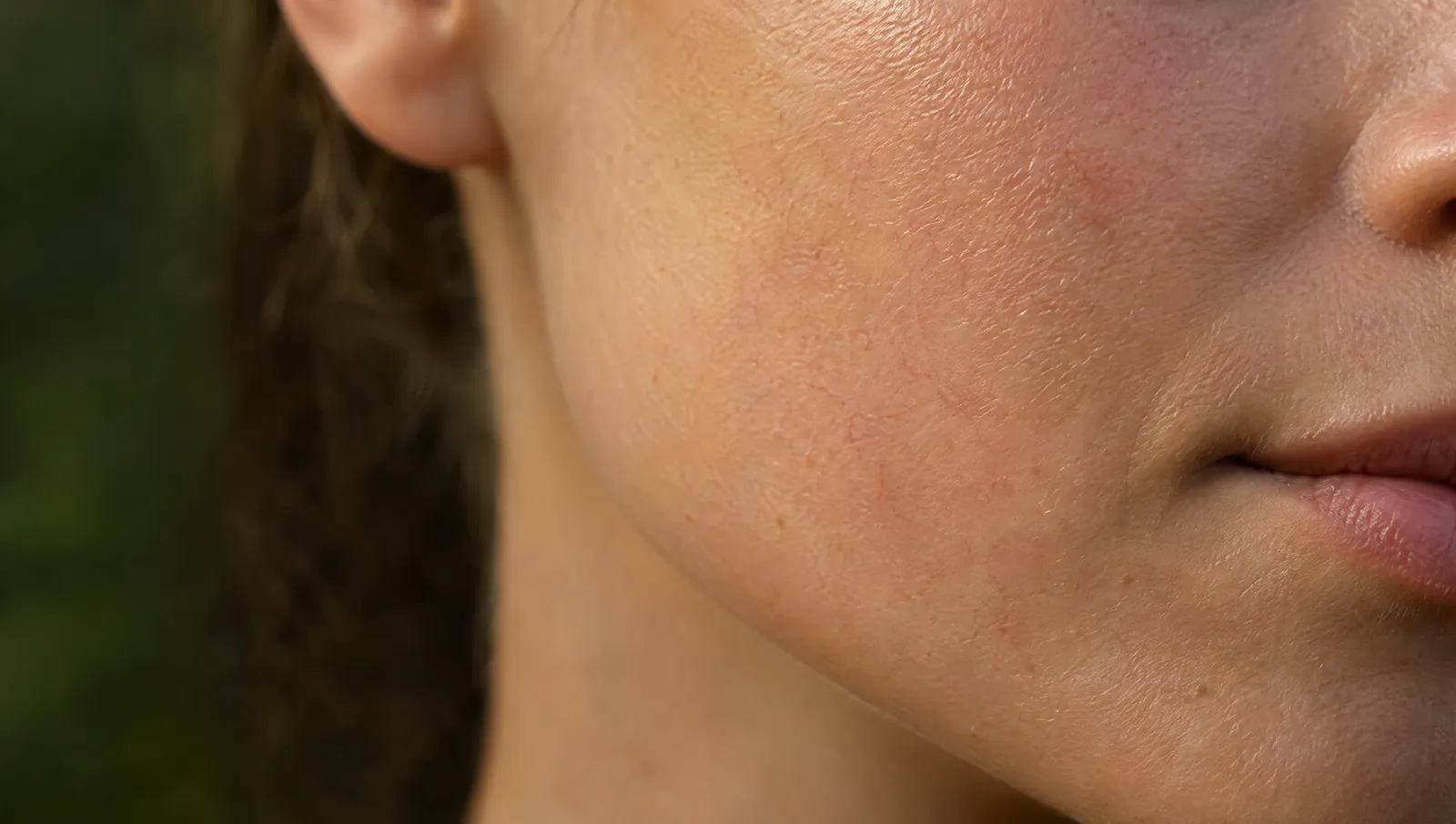 Close-up of the skin on a cheek and jaw in soft light